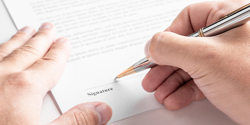 A truck driver signing a loan or lease document