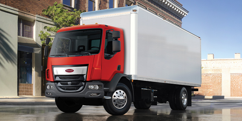 A low cab forward truck in a city